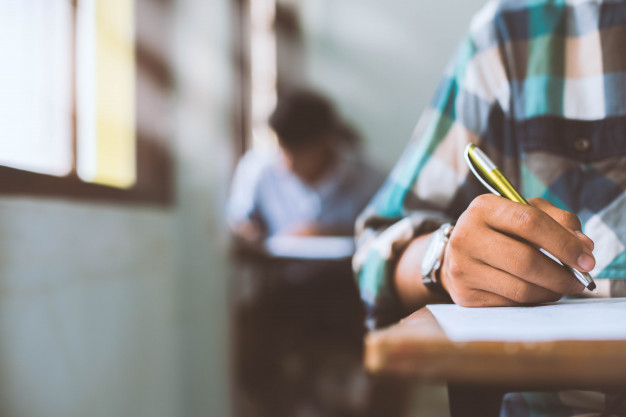 close-up-students-writing-reading-exam-answer-sheets-exercises-classroom-school-with-stress_73622-858